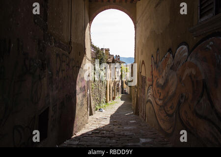 Italien, Arezzo - 12. März 2017: mit dem Blick durch einen Bogen auf einer schmalen Straße von Arezzo an einem sonnigen Tag am 12. März 2017, Toskana, Italien. Stockfoto