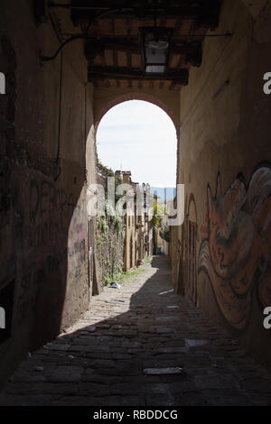 Italien, Arezzo - 12. März 2017: mit dem Blick durch einen Bogen auf einer schmalen Straße von Arezzo an einem sonnigen Tag am 12. März 2017, Toskana, Italien. Stockfoto