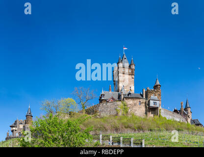 Low Angle Blick auf die berühmte Reichsburg Cochem in der Eifel an der Mosel in Deutschland mit blauem Himmel. Stockfoto