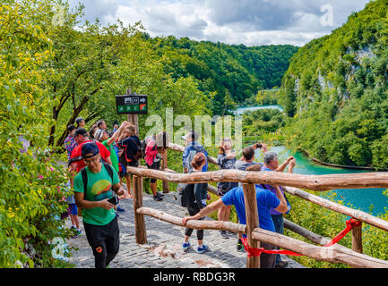 Gruppe von Touristen nimmt Bilder der Wasserfall im Nationalpark Plitvicer Seen, Kroatien Stockfoto