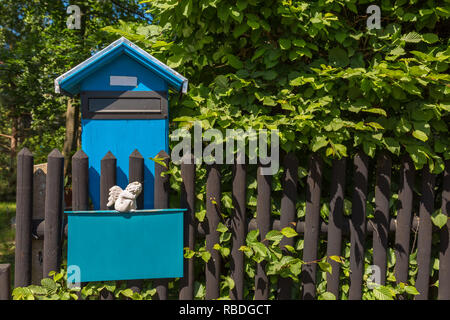 Blau Mailbox mit Engel Abbildung auf einem Zaun Stockfoto
