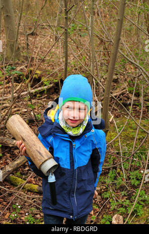 Geocaching Junge findet einen gut getarnten Cache im Wald Stockfoto