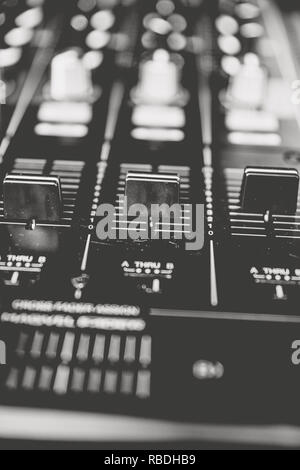 Eine künstlerische Nahaufnahme von Mixer/mix Schreibtisch eines DJ in Schwarz und Weiß. Stockfoto