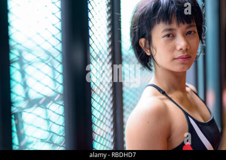 Gesicht der jungen schönen asiatischen Frau an der Turnhalle Stockfoto