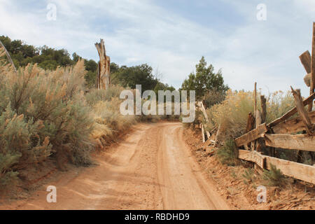 Ein Feldweg führt Sie durch sagebrush und entlang einer abgenutzten Zaun im Capitol Reef National Park, Utah. Stockfoto