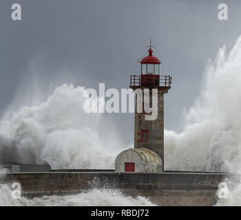 Big stürmischen Wellen über alte Porto Leuchtturm und Pier. Schönes Licht aus Sonnenstrahlen durch Feuchtigkeit gefiltert. Stockfoto