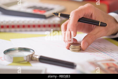 Geschäftsmann Münzen setzen auf Exchange Bericht Stockfoto