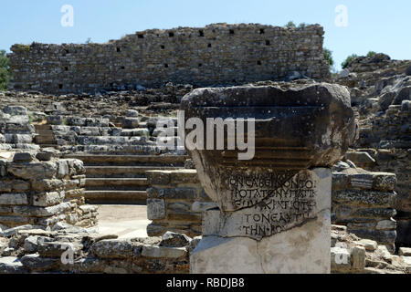 Antike griechische Inschrift. Dahinter ist der bouleuterion, Rat haus in der südwestlichen Ecke der Agora, antiken griechischen Stadt Iasos, Turke Stockfoto