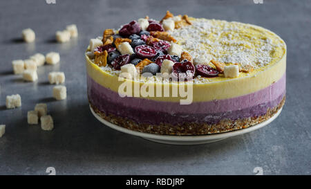 Raw vegan Berry und Mango cheesecake Glutenfreie auf weißem Hintergrund Holz, Kokosnuss Stockfoto