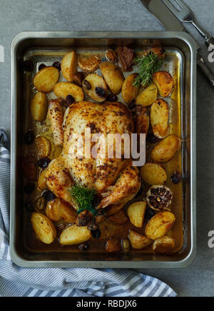 Gebackene Türkei oder saftiges Huhn mit goldenen knusprige Haut mit Trauben und Kartoffeln, Tangerine. Gebratenes Huhn in der auflaufform. Weihnachtsessen. Flach. Ansicht von oben Stockfoto