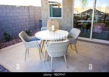 Weissen Korbmöbeln Terrasse Tisch und Stühle mit Mittelstück Stockfoto