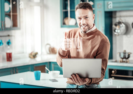 Es ist ok. Art junger Mann zum Ausdruck Positivität während auf Kamera posieren Stockfoto