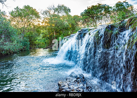 Kleiner Wasserfall und Fluss mit Wasser läuft über die Felsen und zwischen den tropischen Wald in Carrancas, Minas Gerais, Brasilien Stockfoto