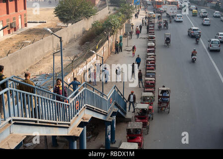 Verkehr Austausch außerhalb Sarita Vihar Metro Station in Neu Delhi: Eine Reihe von Rikschas warten für die Metro Passagiere neben der viel befahrenen Straße. Stockfoto