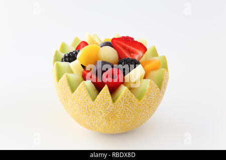 Fancy cut Melone auf einem weißen Hintergrund mit sortierten Obst wie Erdbeeren, Himbeeren, Weintrauben, Pfirsiche, Ananas, in Scheiben geschnitten und Brombeeren Stockfoto