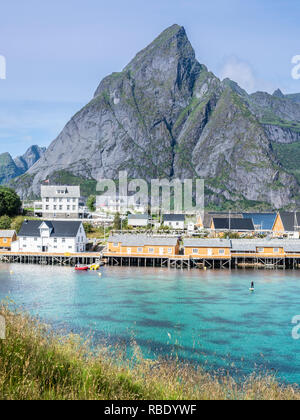 Sakrisøy Fischerdorf, Stand up Paddeln, sup, Gelb fishermans Kabinen am Meer auf der kleinen Insel Sakrisöy, typische Rorbu, in der Nähe von Hamnöy, Moskenesoy Stockfoto