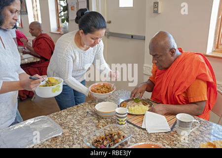 Nach morgen Dienstleistungen, Buddhisten Kongregationsmitglieder füttern ihre Mönch mit hausgemachten Speisen. An der New York Buddhist Vihara in Queens, Dorf. Stockfoto