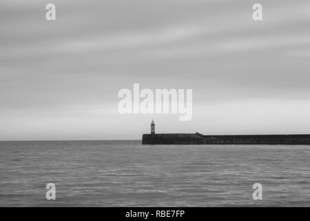 Eine dramatische Schwarzweiß gedreht Der Leuchtturm am Rande von Newhaven Hafen in East Sussex Stockfoto