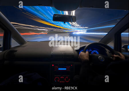 Verkehr nächtliche Trails auf der Autobahn mit Scheinwerfern und leichte Wanderwege auf der Leitung, die bis zu der Kreuzung Dartford Tunnel mit Overhead am Straßenrand Schilder Stockfoto