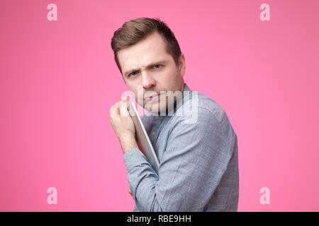 Die Daten, die ich habe, ist streng geheim. Der Mensch seine Tablette Verstecken von seinem Freund. Stockfoto