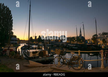 Dämmerung Farben über den alten Hafen von Gouda in Holland. Malerische, typisch holländische Sicht auf mehrere Orte in der Stadt Gouda, Niederlande. Stockfoto