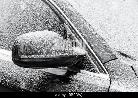Schwarzes auto Spiegel mit frischen Frost und Schnee in kalten Winter abgedeckt Stockfoto