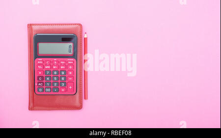 Ansicht von oben in Rot mit rotem calclator auf lebhaften rosa Hintergrund Tisch mit leeren Kopie Raum, Mathematik, Kosten, Steuer- oder Investition Berechnung. Stockfoto