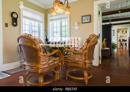 Korbstühlen und runden Glas Tisch in der Familie Zimmer in einem alten Cottage Stil rekonstruiert Canadiana 1886 Wohnhaus Stockfoto