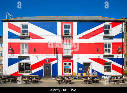 Ein Mann sitzt außerhalb der Europäischen Union Inn Pub an einem klaren Sommertag in Saltash, South East Cornwall, in der Nähe von Plymouth, Devon. England, Vereinigtes Königreich. Stockfoto