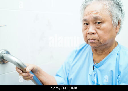 Asiatische Senior oder ältere alte Dame Frau Patienten benutzen Wc griff Sicherheit in der Krankenpflege Krankenhaus. Stockfoto