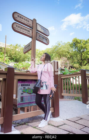 Taipei, Taiwan - 24. November 2018: asiatische Frau touristische Ansätze für die Infomation unterzeichnen, Beitou Park, Taipei, Taiwan. Stockfoto