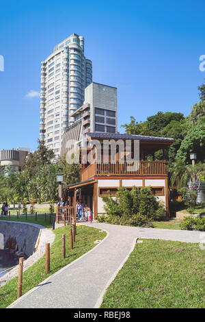 Taipei, Taiwan - 24. November 2018: Gehweg im Garten mit hohen Gebäude in der Szene in Beitou Park, Taipei, Taiwan. Stockfoto