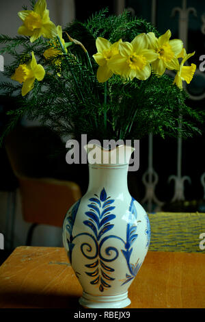 Einen Strauß Narzissen von verschiedenen Sorten. Blumen in einer Vase und Schale auf dem Tisch. Retro noch leben. Narzisse Stockfoto