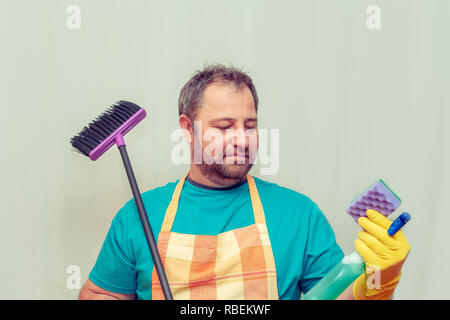 Emotionale bärtiger Mann mit einem Besen. Hellen Hintergrund. Stockfoto