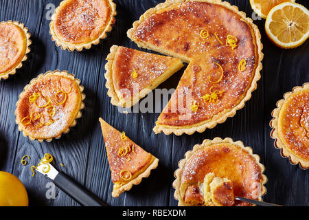 In der Nähe von Schweizer Ostern Dessert - griess Kuchen mit Puderzucker und der Zitronenschale bestreut, Torte de Paques, Osterfladen, auf einem Schwarzen Tisch mit l Stockfoto