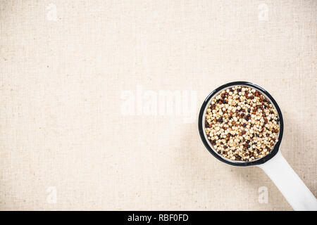 Quinoa Samen in Keramik Löffel, superfood. Kopieren Sie Speicherplatz auf Küche Tuch mit Spotlight. Stockfoto