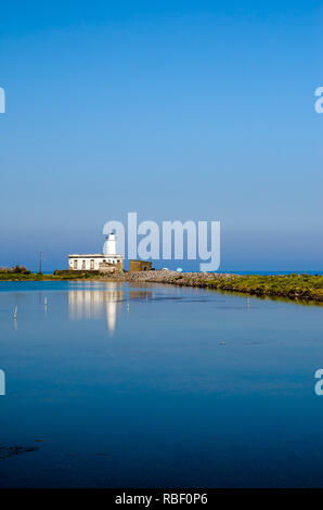 Der Leuchtturm von Punta Lingua über einem Teich auf der Insel Salina in der Äolischen Inseln, Sizilien, Italien Stockfoto