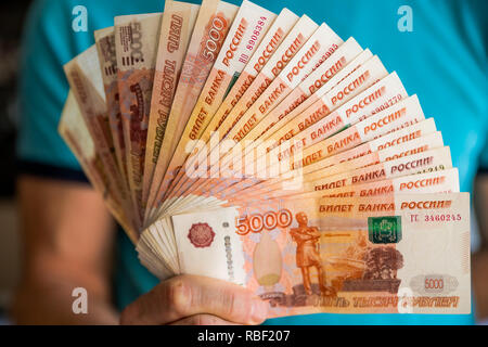 Fünf tausend Russische Rubel in der Hand auf weißem Hintergrund. Bündel Banknoten von 5000 Rubel der Russischen Föderation. Hand mit Russischen Banknote. Russische Geld Hintergrund. Stockfoto