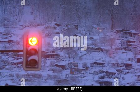 Aue, Deutschland. 10 Jan, 2019. Eine Ampel an der Kreuzung rot leuchtet, während im Hintergrund die schneebedeckten Garten und Bungalows sehen können. Credit: Sebastian Willnow/dpa-Zentralbild/dpa/Alamy leben Nachrichten Stockfoto