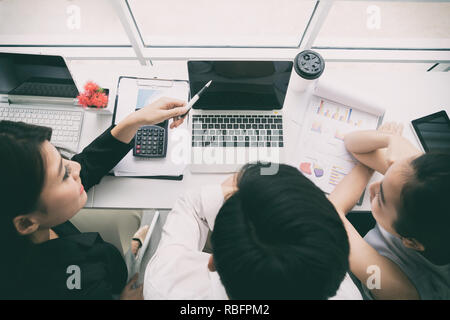 Blick von oben auf die asiatischen Geschäft Leute Gruppe zu treffen, Geschäfte, die Diskussion in der modernen hellen Büro indoor mit Tablet-PC. Vintage Ton. Stockfoto
