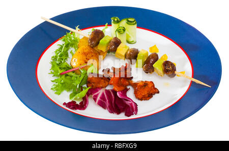 Gegrilltes Huhn Herz am Spieß mit Avocado mit gebratenen Pfifferlingen und Gemüse serviert. Auf weissem Hintergrund Stockfoto