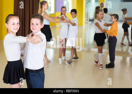 Paare der Kinder tanzen Walzer in der Klasse. Stockfoto
