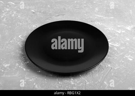Blick von oben auf die Matte runde Leere schwarze Platte auf dunklen Zement Hintergrund Kopie Platz für Sie entwerfen. Perspektive betrachten. Stockfoto