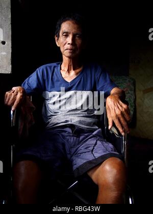 ANTIPOLO, Rizal, Philippinen - Januar 2, 2019: Ein erwachsener Mann im Rollstuhl sitzt am Fenster seines Hauses. Stockfoto