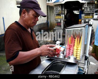 ANTIPOLO, Rizal, Philippinen - Januar 2, 2019: einem Straßenhändler verkauft Eis auf einem Kegel auf seinem eiswagen. Stockfoto