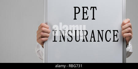 Männer Hände halten ein Plakat mit der Aufschrift Pet Insurance auf hellen Hintergrund isoliert Stockfoto