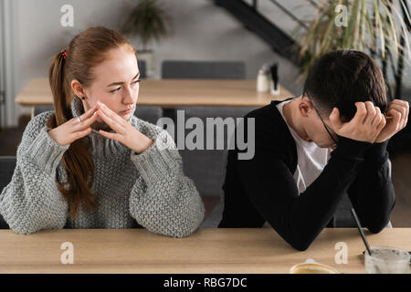 Schlechte Beziehung Konzept. Der Mann und die Frau in der Uneinigkeit. Junges Paar nach Streit sitzen nebeneinander. Im Freien Stockfoto