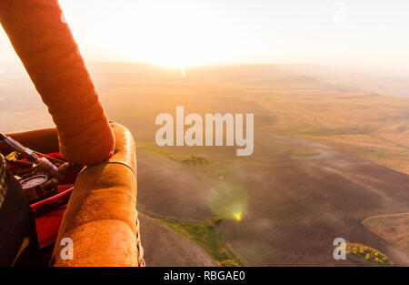 Hot Air Balloon busket bei Sonnenaufgang über das Tal fliegen Stockfoto