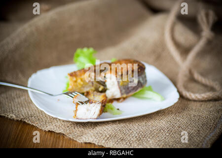 Stück gebratener Fisch in einer Platte auf einer hölzernen Stockfoto