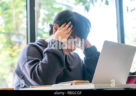 Asian kurzhaar Freiberufler fühlen mit Job betonte Stockfoto
